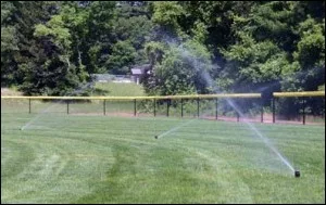 Sprinklers watering a baseball outfield