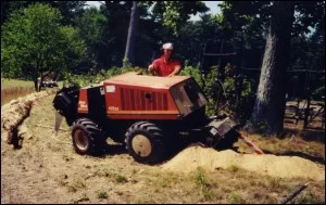 Crew member operating a trenching machine during an installation